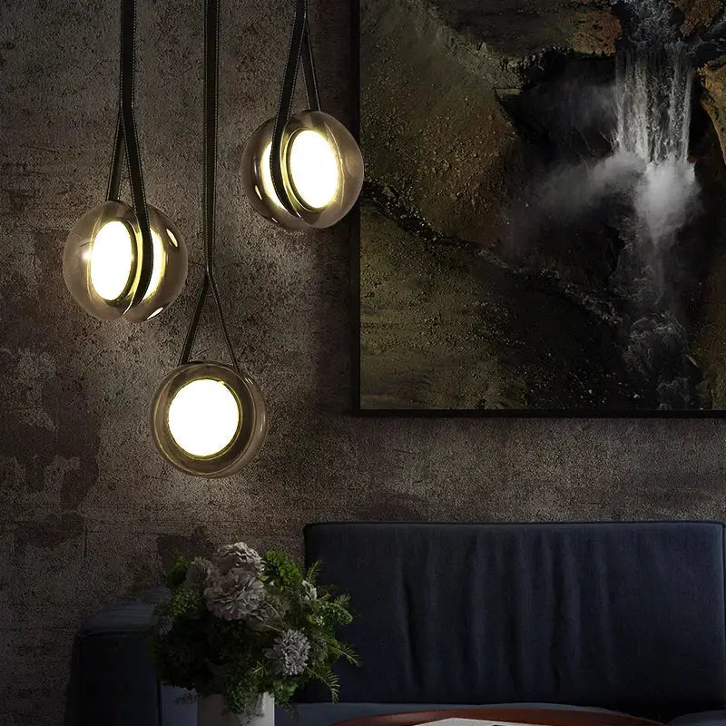 Three modern clear glass designer pendant lights with spherical shades and black straps for bedroom decorbites pendant lights