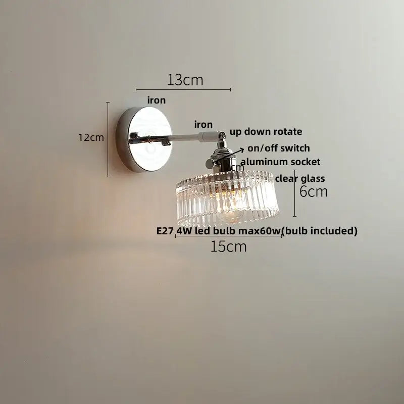 A sleek chrome wall lamp with a clear glass chandelier-style shade by decorbites clear glass for bedroom decor