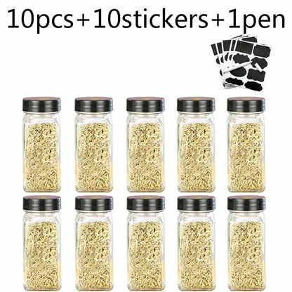 Set of ten modern clear glass seasoning jars with black lids filled with dried herbs for kitchen use