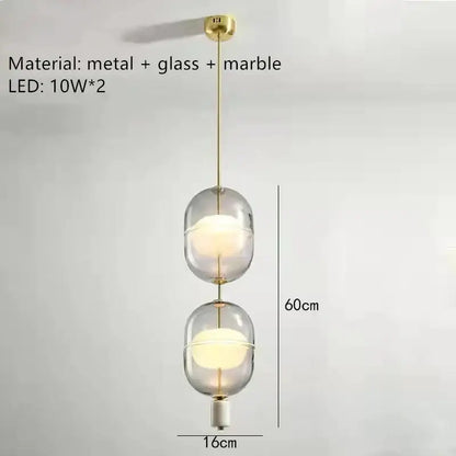 Modern pendant light with two oval clear gray amber glass globes, brass metal accents, and marble details for dining room decorbites clear gray