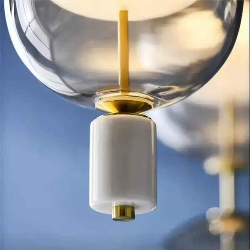 Modern clear gray amber glass pendant light with gold-toned metal and white ceramic base for dining room decorbites clear gray