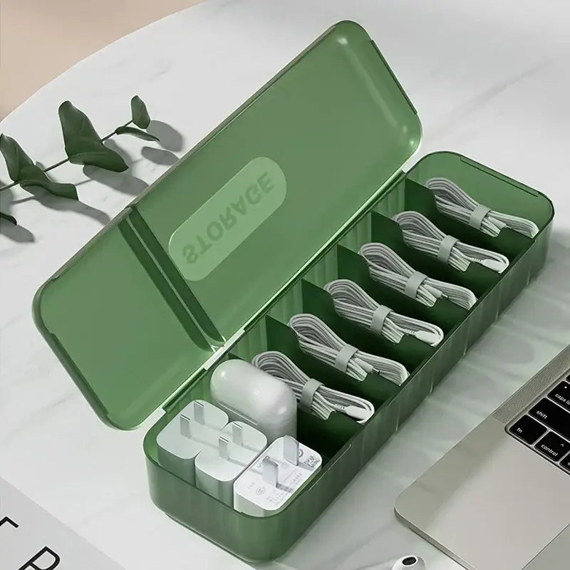 Green translucent decorbites cable box with six compartments holding white charging cables and power adapters for bedroom use