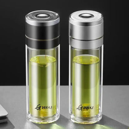 Two transparent decorbites insulated glass cups with silver and black lids containing green liquid