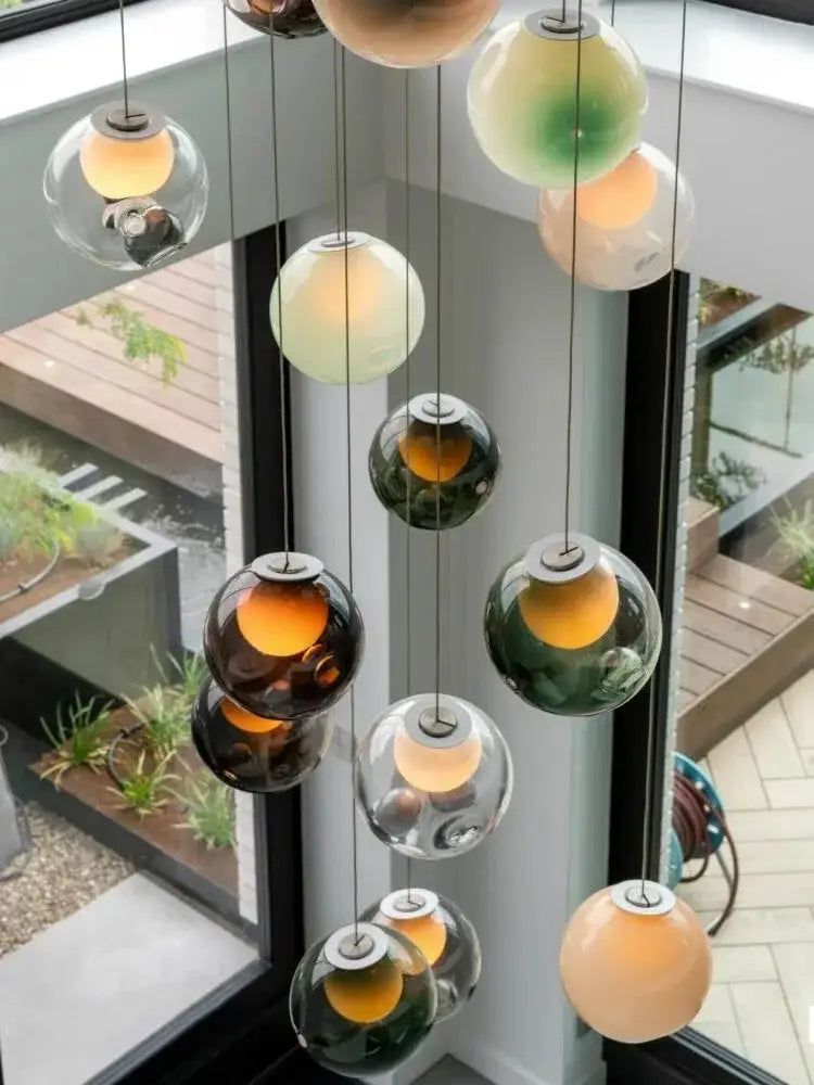 A modern colorful balls chandelier with amber green and clear glass globes by decorbites for dining room decor