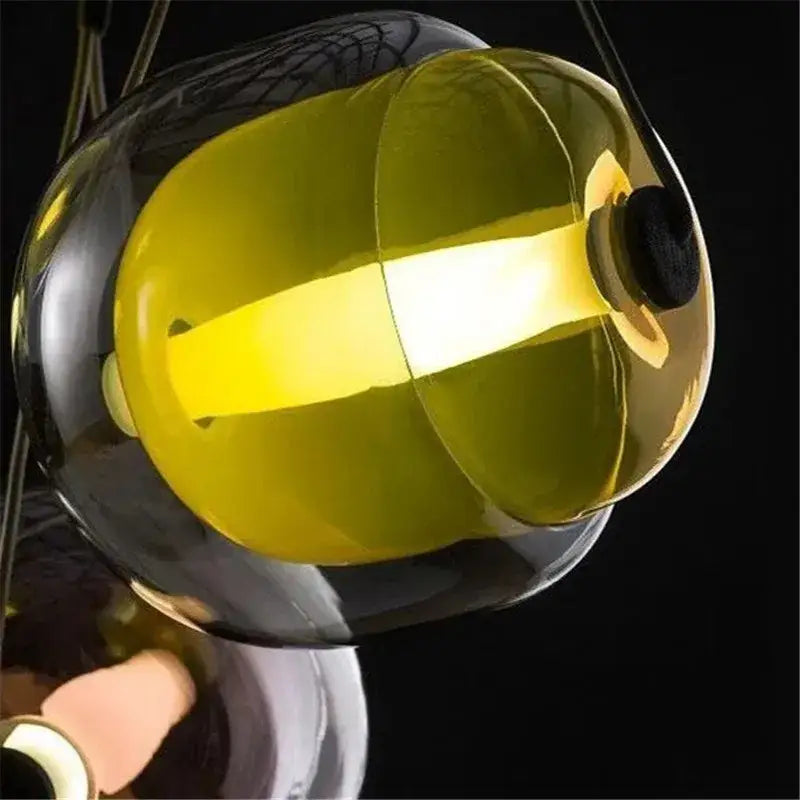 Modern colorful Czech glass capsule pendant light with translucent yellow shade and dark reflective casing for dining room