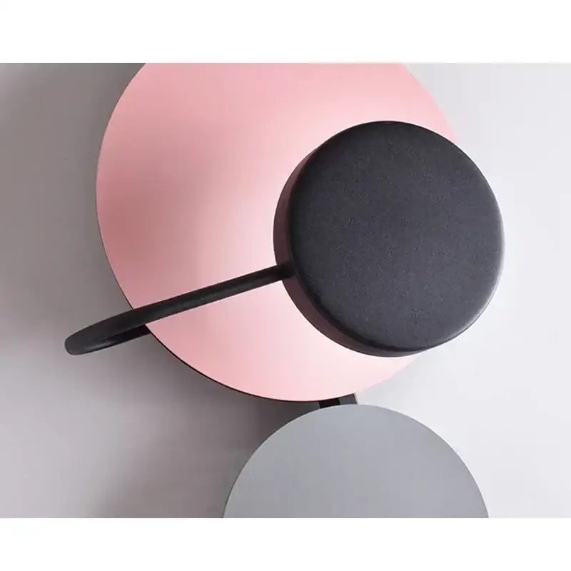 Modern colorful geometric led wall lamp with matte pink base and black cylindrical lamp head for bedroom decor