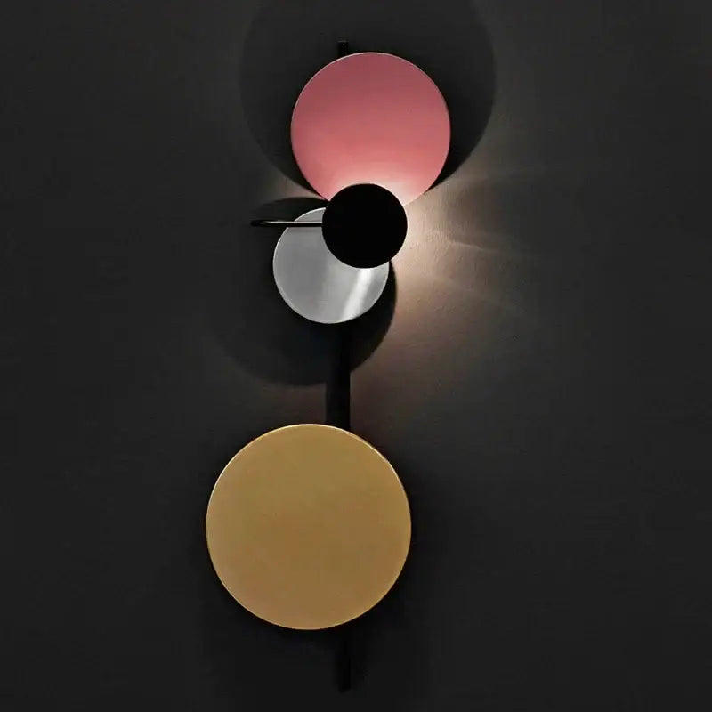 Modern colorful geometric led wall lamp with three stacked circular pink black and gold shades for bedroom decor