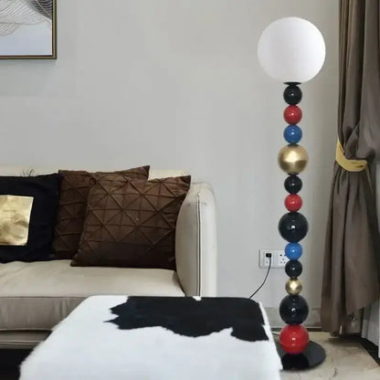 Modern floor lamp with a white spherical shade and a stacked column of colorful glass ball spheres for living room