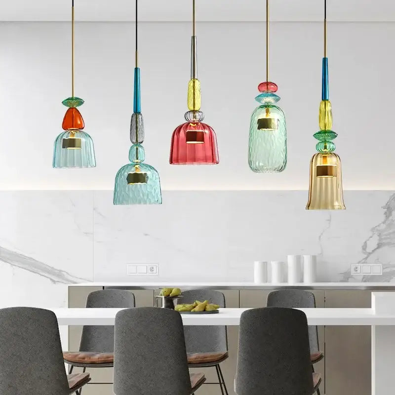 Five colorful glass led pendant chandeliers with textured bell-shaped shades in teal red and gold for kitchen dining