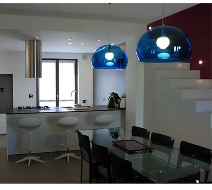 Two vibrant blue dome pendant lamps made of translucent material hang as decorbites colorful dining room lights