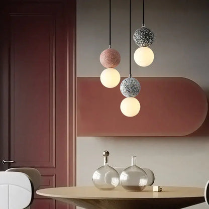 Modern concrete and glass pendant light with iron finish featuring matte pink, speckled gray, and white spherical shades
