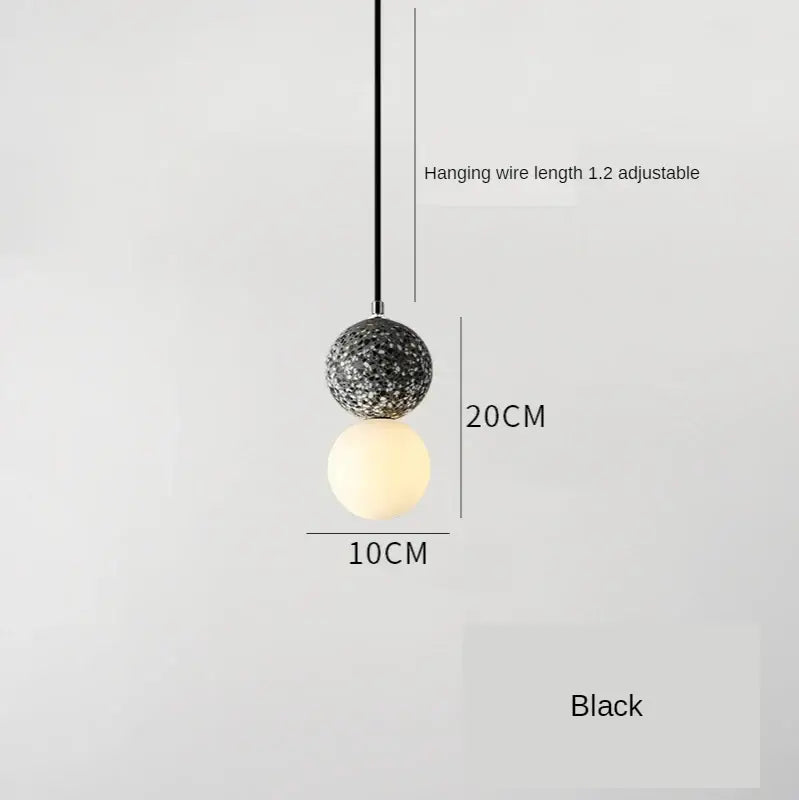 Modern pendant light with iron finish featuring textured speckled and smooth frosted glass spheres for dining room