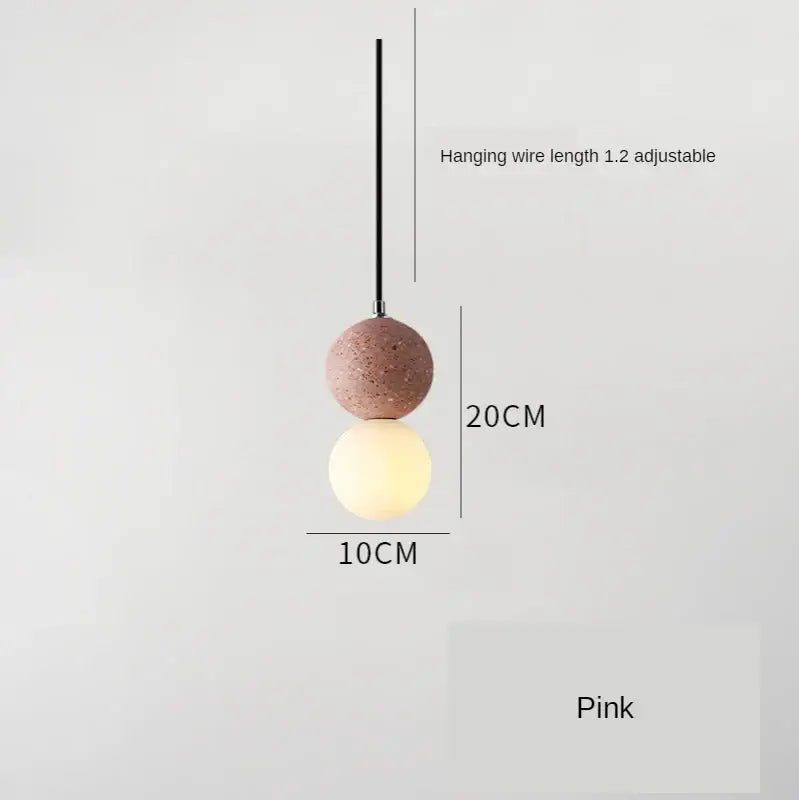 Modern concrete and glass pendant light with pink spherical iron finish featuring textured upper and smooth illuminated globe