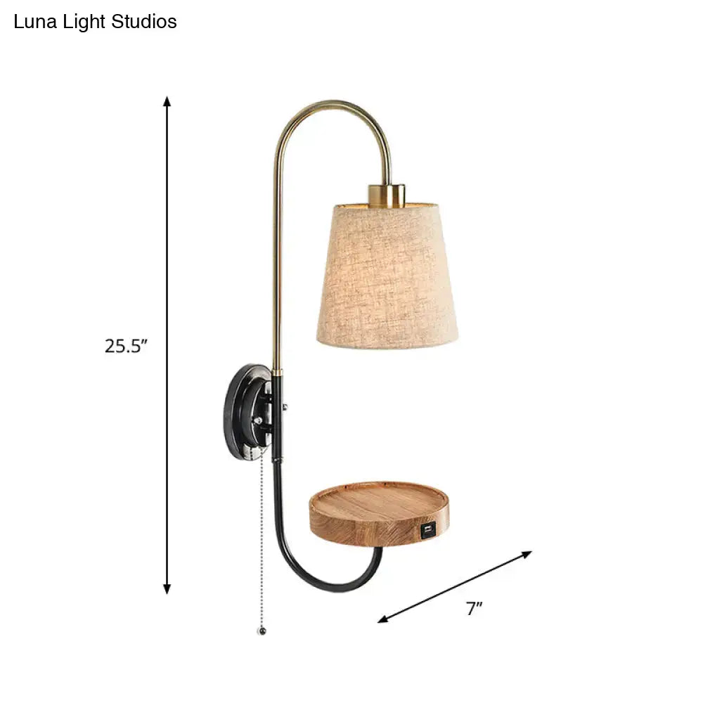 Brass-finished wall mount lamp with conical fabric beige shade, wooden tray, pull chain, and integrated usb port