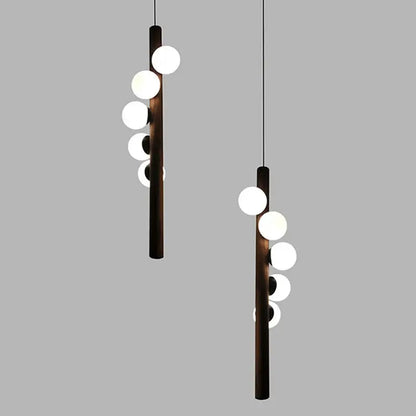 Modern pendant light with dark wooden cylindrical bodies and white spherical bulbs in decorbites burly wood walnut finish