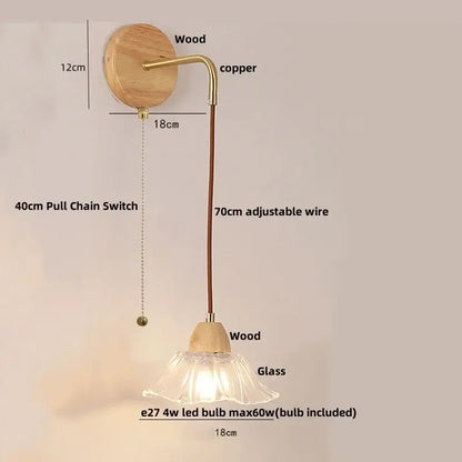 Modern copper and wood wall sconce with clear glass bell shade and pull chain switch on circular wooden backplate