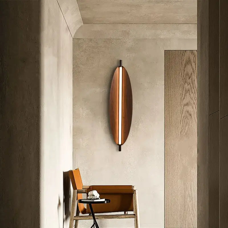 A sleek modern copper brown metal leaf wall sconce with elongated vertical light strip for bedroom decorbites brown metal