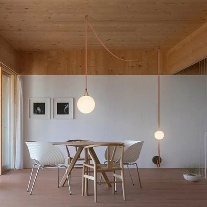 Modern copper decorbites glass ball pendant lamp with a frosted glass ball shade suspended by a copper cord for dining room