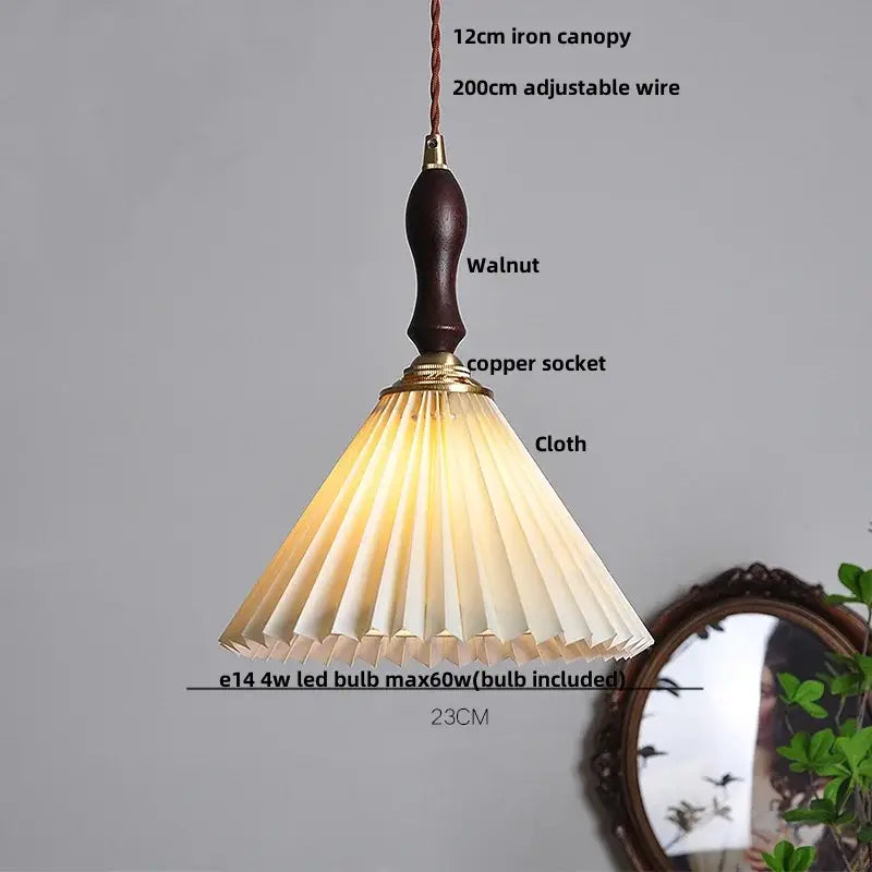 A warm-toned pleated fabric lampshade with dark walnut handle and brass accents on modern copper led pendant lamp