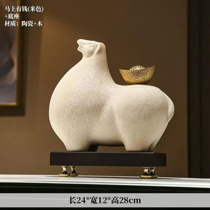 Modern cream and gold horse sculpture figurine decorbites with ceramic material and gold coin detail on dark wooden base
