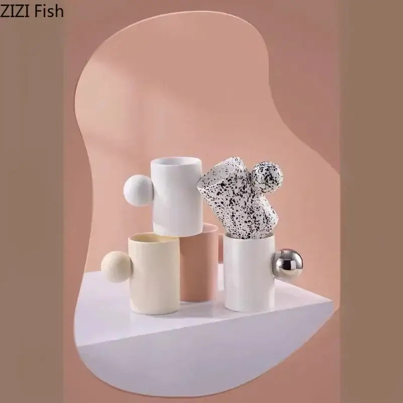 Modern cream ceramic cup and saucer set with speckled black pattern and spherical handles perfect for decorbites cotton candy