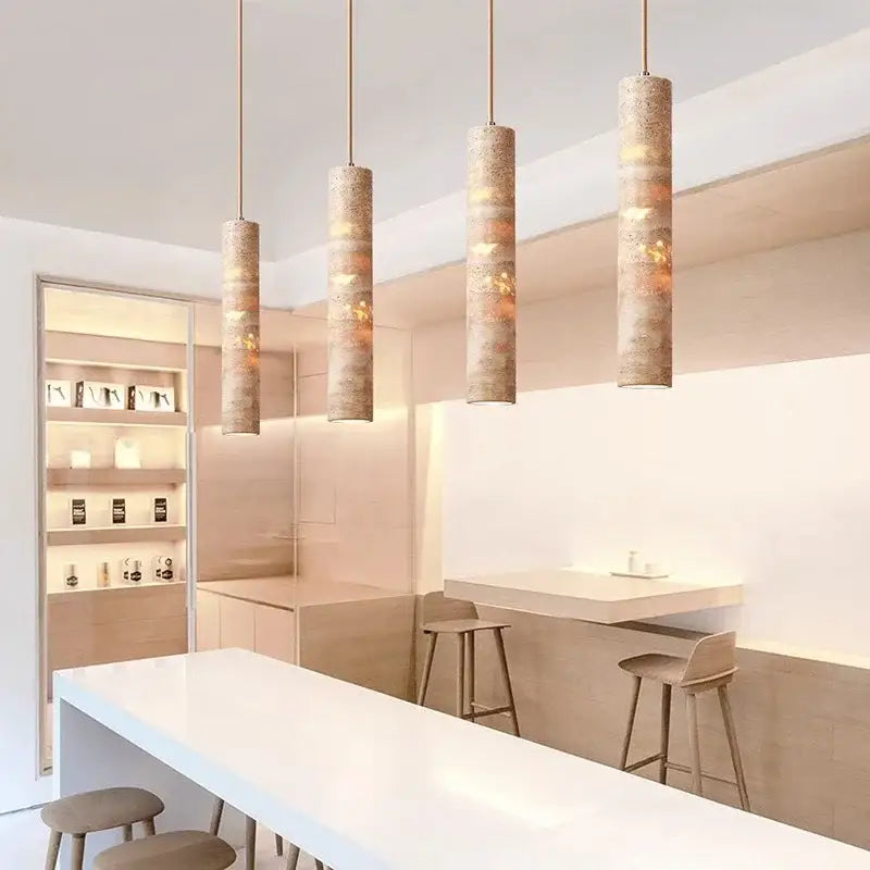 Modern cream concrete pendant light with four textured earthy-toned cylindrical cord pendants as a dining room light source