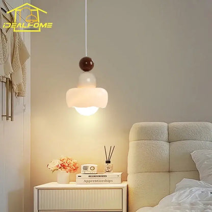 A modern pendant light with a frosted glass shade and dark brown top for decorbites cream bedroom decor