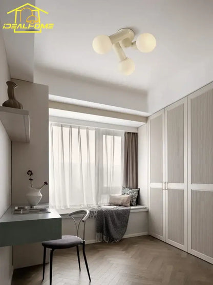 Off-white cream wind led ceiling light with three frosted glass globe bulbs in a modern minimalist bedroom design