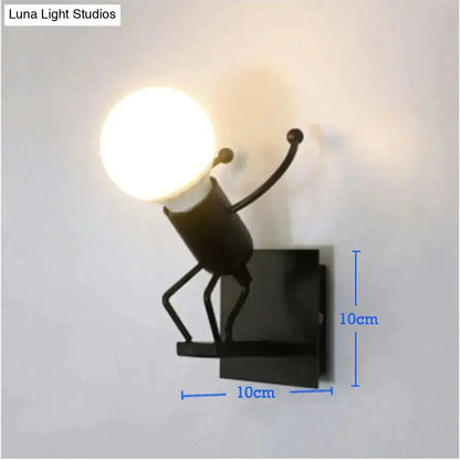 Black metal wall sconce in creative minimalism metal robot design holding an illuminated bulb for modern bedroom light