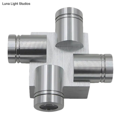 Silver brushed finish cross aluminum wall mount lamp featuring a metallic cross-shaped component with cylindrical ports