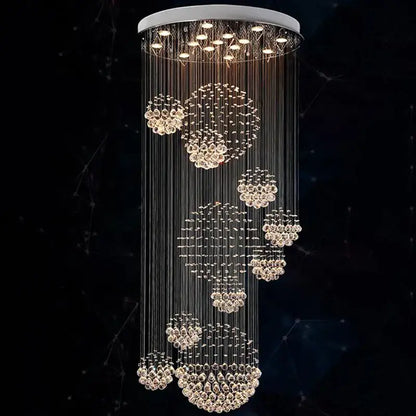 A modern crystal ball chandelier with a sleek white circular top and cascading clear faceted crystals by decorbites