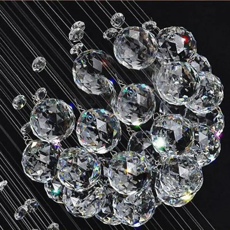 A cluster of clear faceted crystal spheres suspended by thin wires in a decorbites crystal chandelier