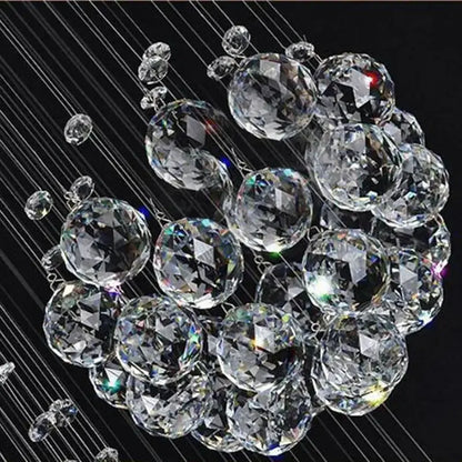 A cluster of clear faceted crystal spheres suspended by thin wires in a decorbites crystal chandelier