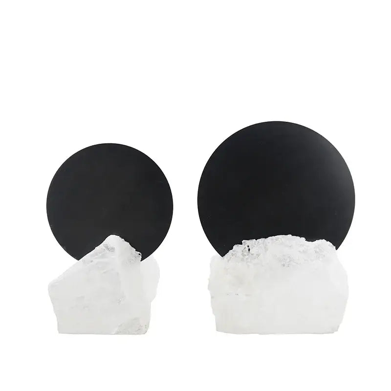 A pair of modern crystal geometric metal sculpture bookends with black circular tops and white quartz bases for decorbites living room