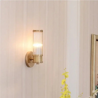Modern crystal led gold wall sconce with a gold-toned cylindrical glass shade featuring vertical ridges for bedroom decorbites crystal led lighting