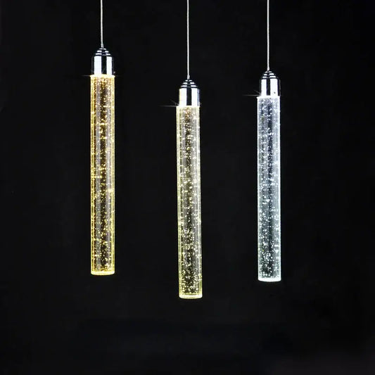 Three modern cylindrical decorbites crystal led pendant lights with chrome tops and glowing clear glass for dining room decor