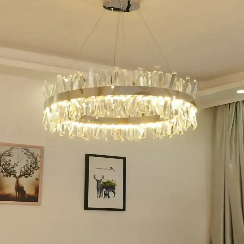 A modern crystal led ring chandelier with metallic frame and clear crystals emitting warm light for luxury decorbites decor