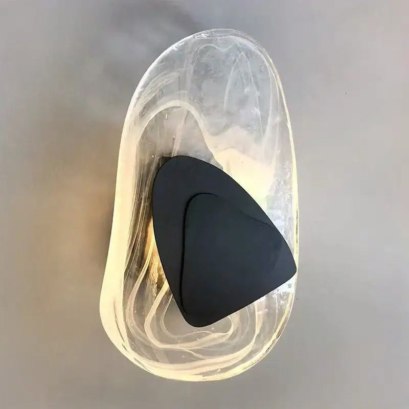 Modern crystal led wall lamp with bronze accent features a transparent sculpted glass bowl holding a black triangular object