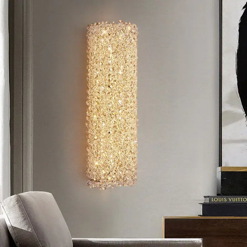 Modern crystal wall lamp featuring a tall rectangular gold sconce with sparkling clear crystals emitting warm glow