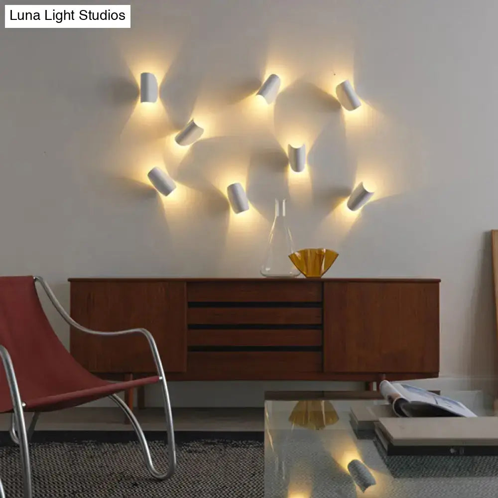Set of nine white cylindrical wall sconce lights with angled warm lighting for modern curved gold bedroom ambient lighting