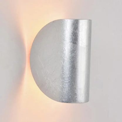 Modern curved gold wall sconce light with brushed metallic finish and subtle texture for bedroom ambient lighting