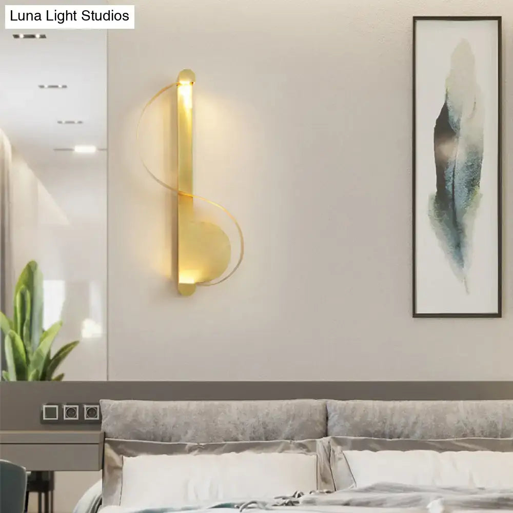 Modern curved gold wall sconce with sleek design emitting warm white light for bedroom ambient lighting