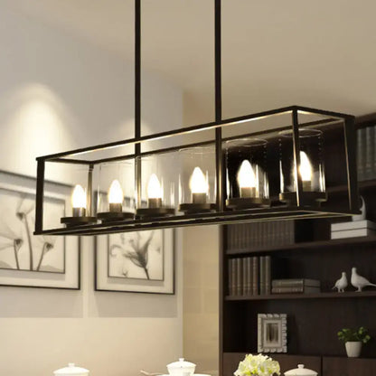 Black metal rectangular chandelier with clear glass shade and five illuminated candle-style bulbs for dining room lighting