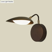 Modern dark bronze oval wall mount sconce with a sleek curved arm and leaf-shaped shade for bedroom lighting