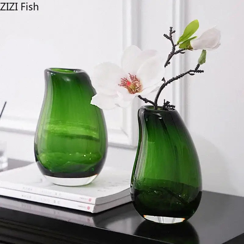 Two translucent emerald green glass vases with smooth teardrop shapes in modern dark gray double glass vase hydroponic decor