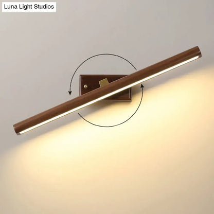 Modern dark wood linear wall sconce with warm-toned wooden finish and adjustable angle for bathroom vanity lighting