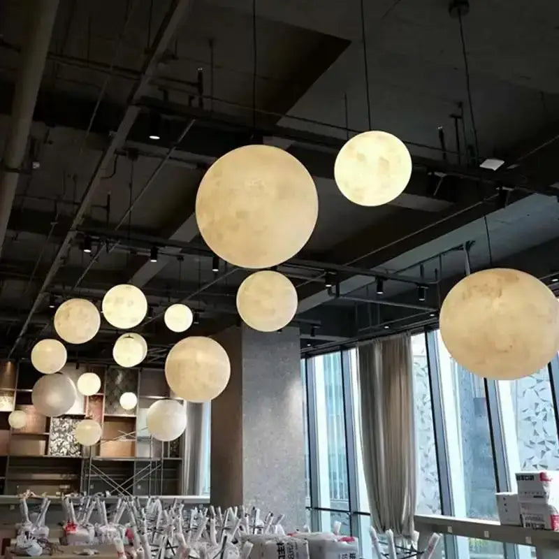 Warm softly glowing cream moon led spherical pendant chandelier by decorbites with textured crater surface for living room