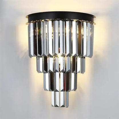 A modern decorbites crystal gold multi-tiered chandelier with cascading crystal prisms on a black circular base