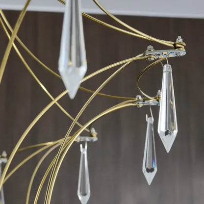 A modern decorbites deluxe crystal star lamp chandelier with slender gold metal arms and clear crystal teardrop pendants