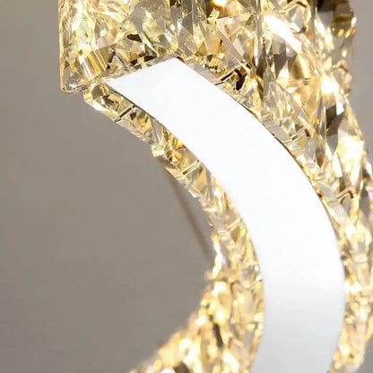 A modern double ring decorbites crystal ceiling chandelier with a white metal frame and golden faceted crystals